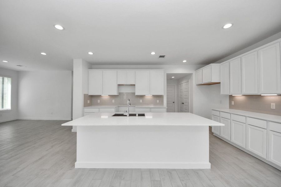 Discover another perspective of this stunning kitchen, generously appointed with an abundance of counter space. Sample photo of completed home with similar floor plan. Actual colors and selections may vary.