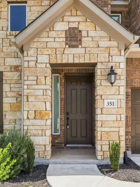 An inviting stone and brick facade welcomes you to this charming residence with a covered entryway. An inviting stone and brick facade welcomes you to this charming residence with a covered entryway.