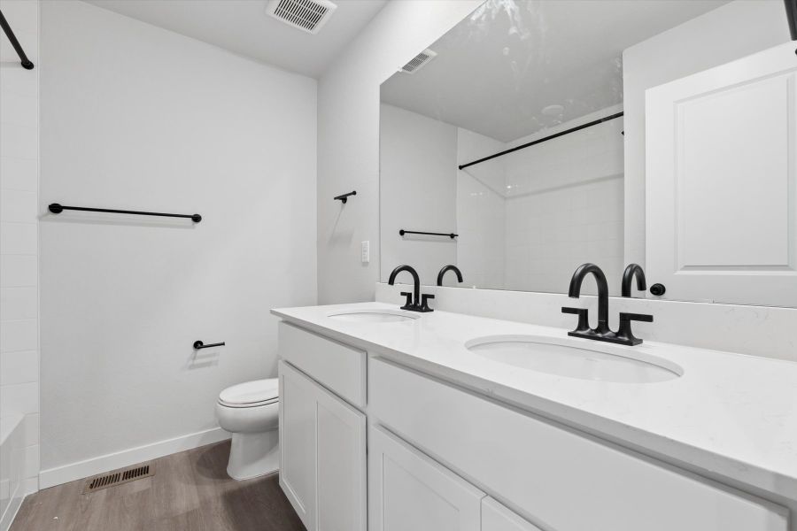 A bathroom with a sink toilet and mirror. A bathroom with a sink toilet and mirror.