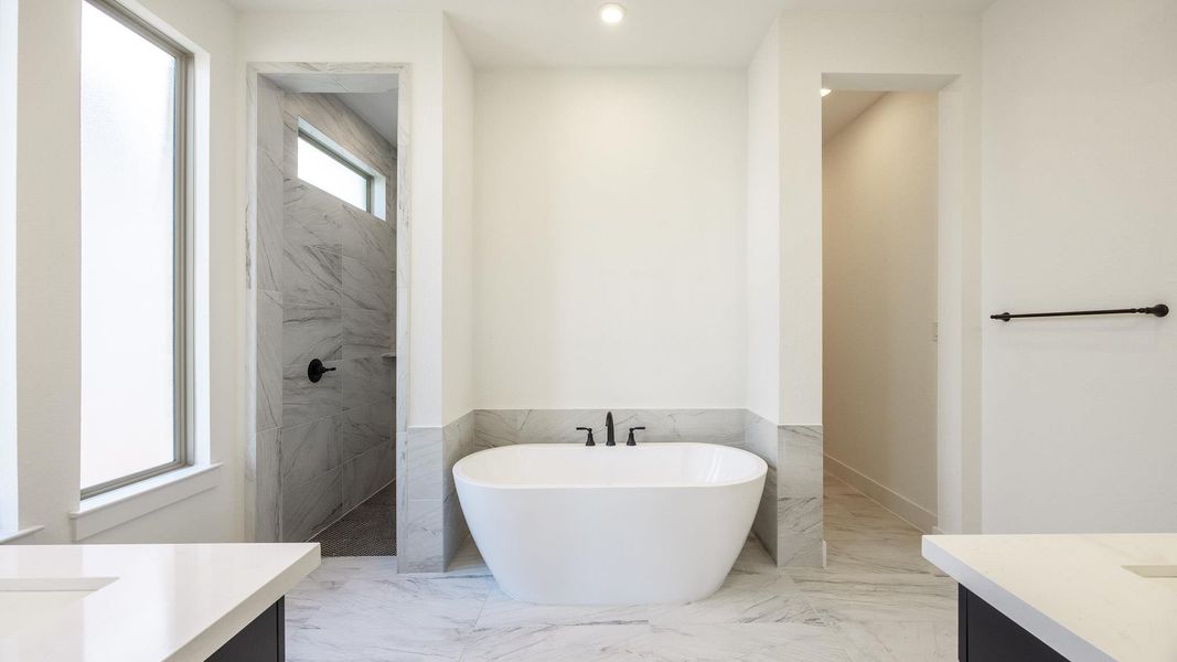 Full bathroom featuring vanity, a soaking tub, light marble finish floors, walk in shower, and tile walls