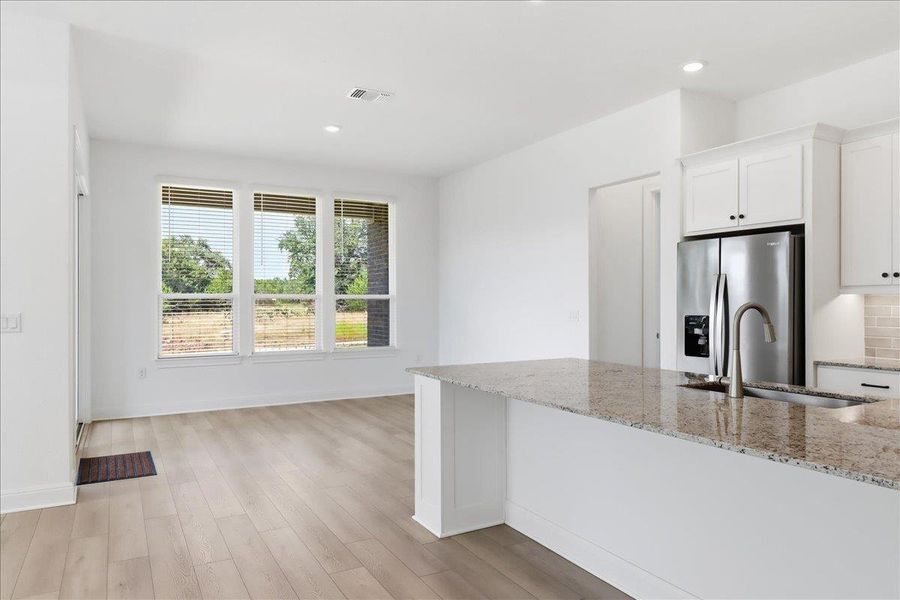 A spacious, airy kitchen and living area featuring plentiful natural light and modern finishes. A spacious, airy kitchen and living area featuring plentiful natural light and modern finishes.