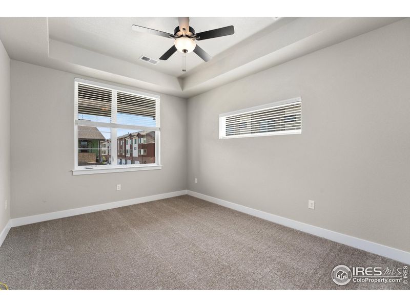 Primary bedroom w/ included ceiling fan and couffered ceiling.