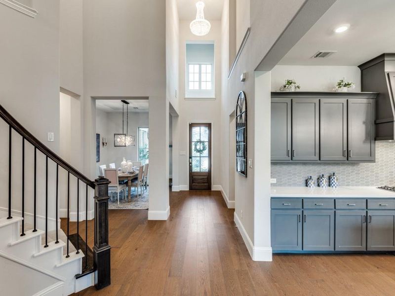 Entryway with a chandelier, a high ceiling, wood finished floors, and stairway