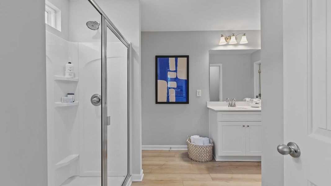 Bright bathroom featuring modern design, quartz vanity tops, sleek finishes, and ample lighting in new townhome.