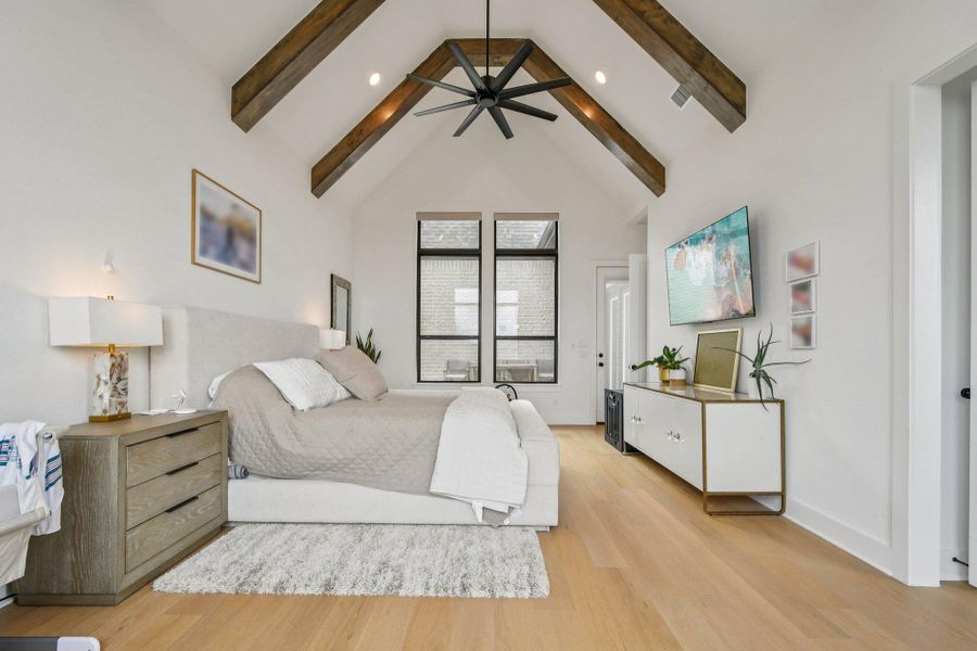 This room features a vaulted ceiling with exposed wooden beams, light-toned wooden flooring, and large windows providing natural light This room features a vaulted ceiling with exposed wooden beams, light-toned wooden flooring, and large windows providing natural light