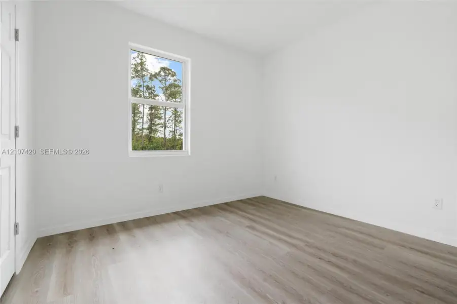 Neutral wall finishes, wood-finish flooring, and a single-hung window Neutral wall finishes, wood-finish flooring, and a single-hung window