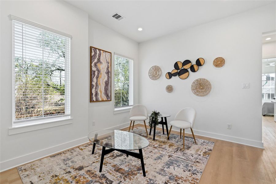 This bright secondary living area is defined by high ceilings and wide-plank vynil flooring.