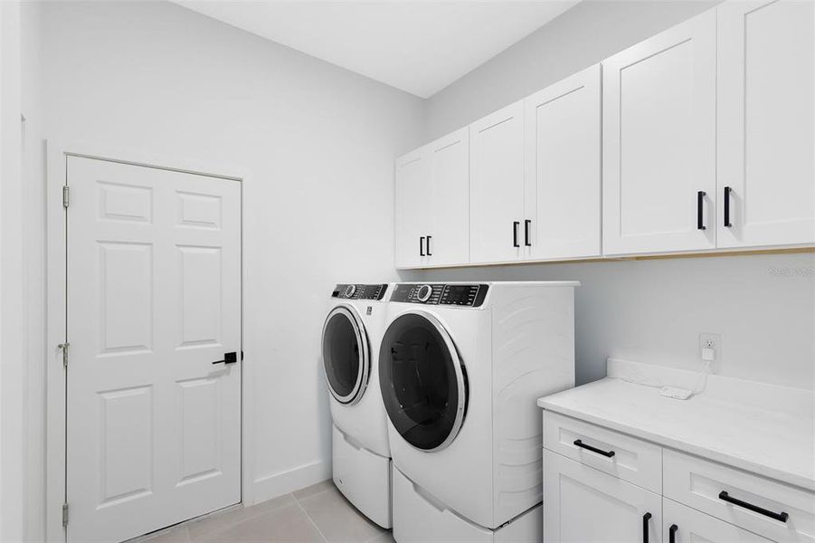 Your laundry room features a sink and cabinet space for storage.