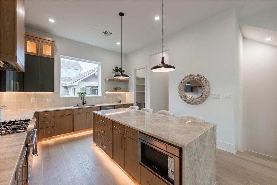 Morning coffee, morning light. The sink faces the window, the island faces the room, and the pantry hides the clutter. Three decisions that separate a kitchen that photographs well from one that works.