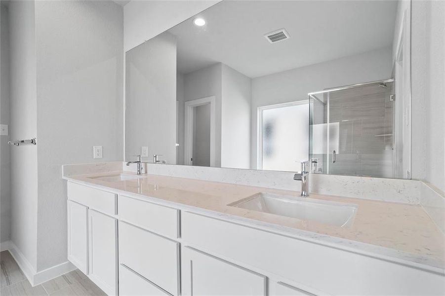 This primary bathroom is definitely move-in ready! Featuring stained cabinets with light countertops, spacious walk-in closet with shelving, high ceilings, custom paint, sleek modern finishes.