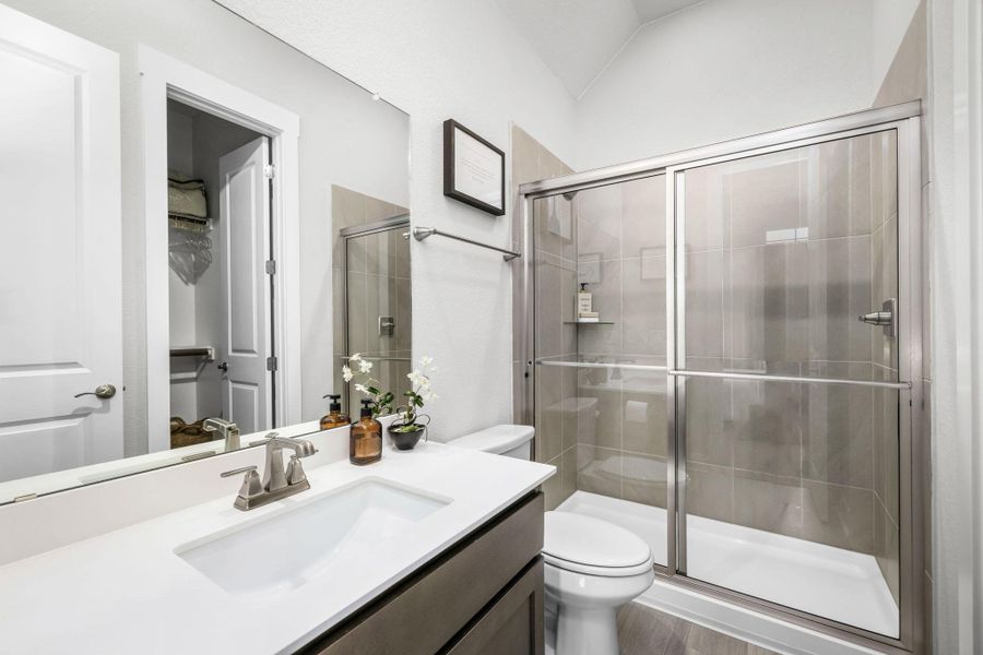 A well-appointed bath features a sleek shower and an elegant vanity.