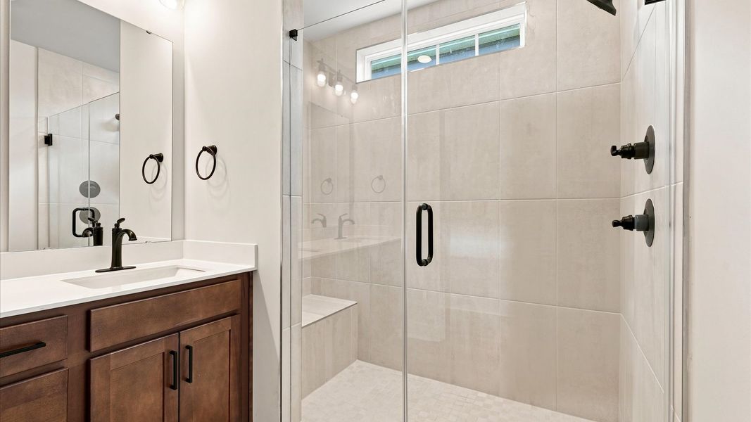Highly functional and elegant en-suite with dual vanities, tiled walk-in shower, and refined finishes