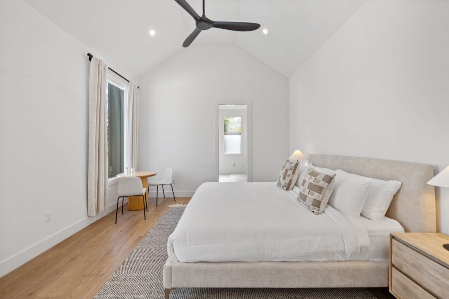 Bedroom featuring light wood-style floors, vaulted ceiling, recessed lighting, and ceiling fan