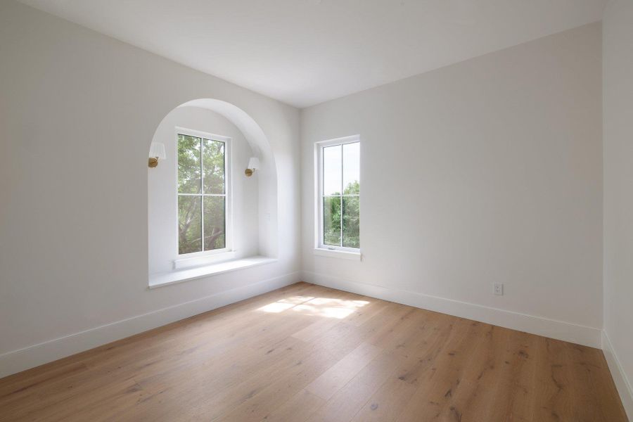 Secondary bedroom with arched bench seating.