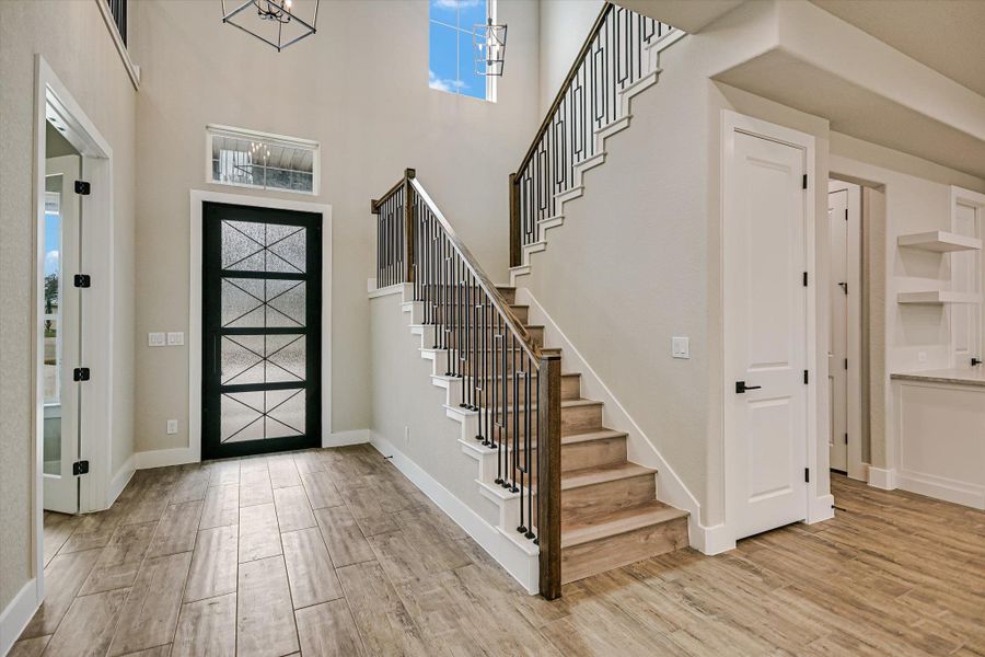 Entrance foyer featuring light wood-style flooring and a high ceiling
