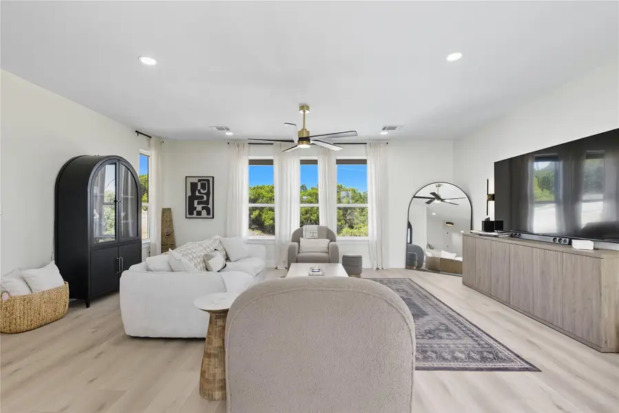 Living area featuring ceiling fan, healthy amount of natural light, light wood-style floors, and recessed lighting