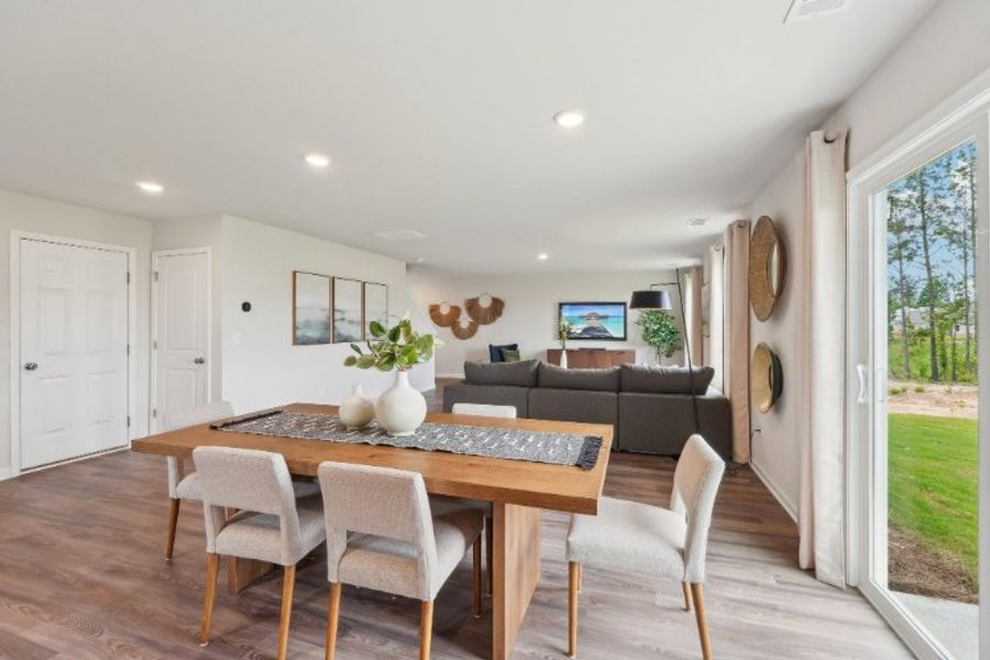 A living room with a table and chairs. A living room with a table and chairs.