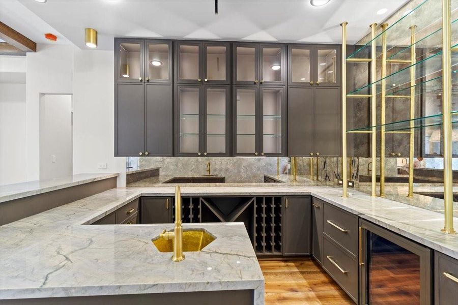 Bar features a lot of storage as well as paneled drink drawers, a wine refrigerator and an ice maker