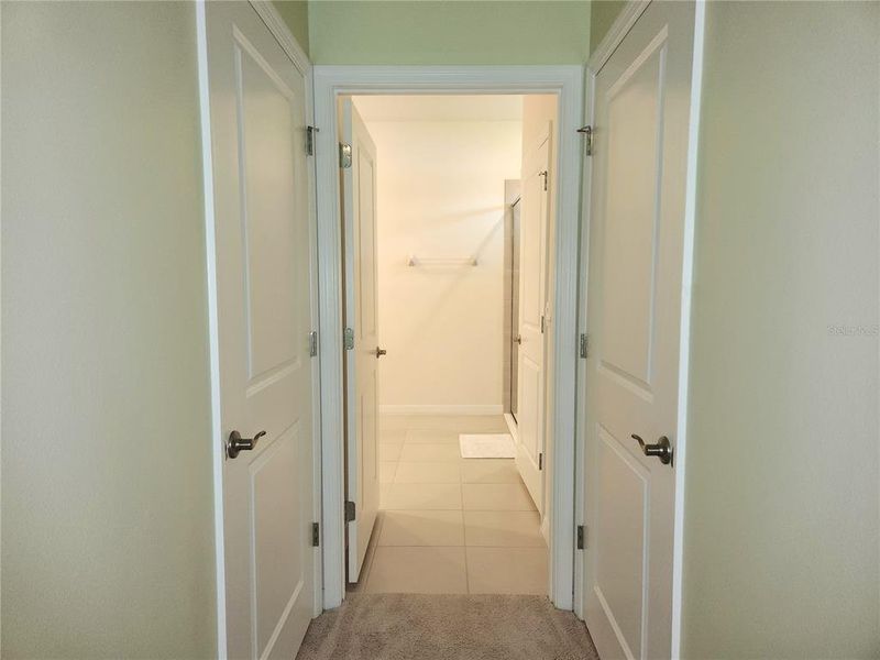 Doors to walk-in closets then on to the primary bathroom
