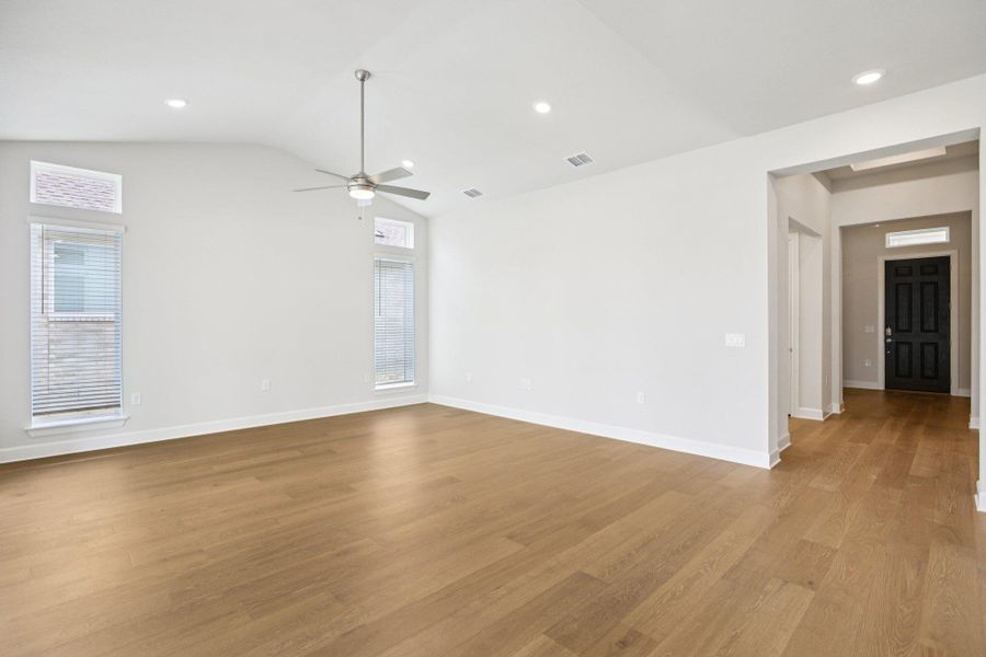 Empty room featuring light wood-style floors, recessed lighting, and vaulted ceiling
