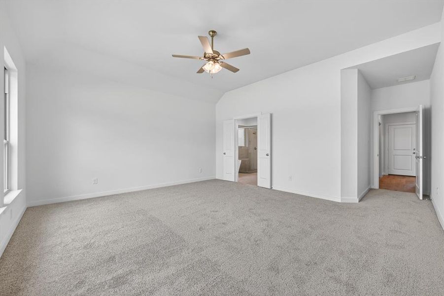 Spacious room featuring vaulted ceilings and light gray carpeting