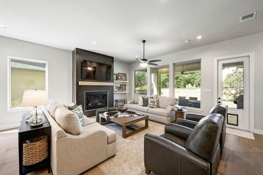 Living room with hardwood / wood-style flooring, a fireplace, recessed lighting, and a ceiling fan Living room with hardwood / wood-style flooring, a fireplace, recessed lighting, and a ceiling fan