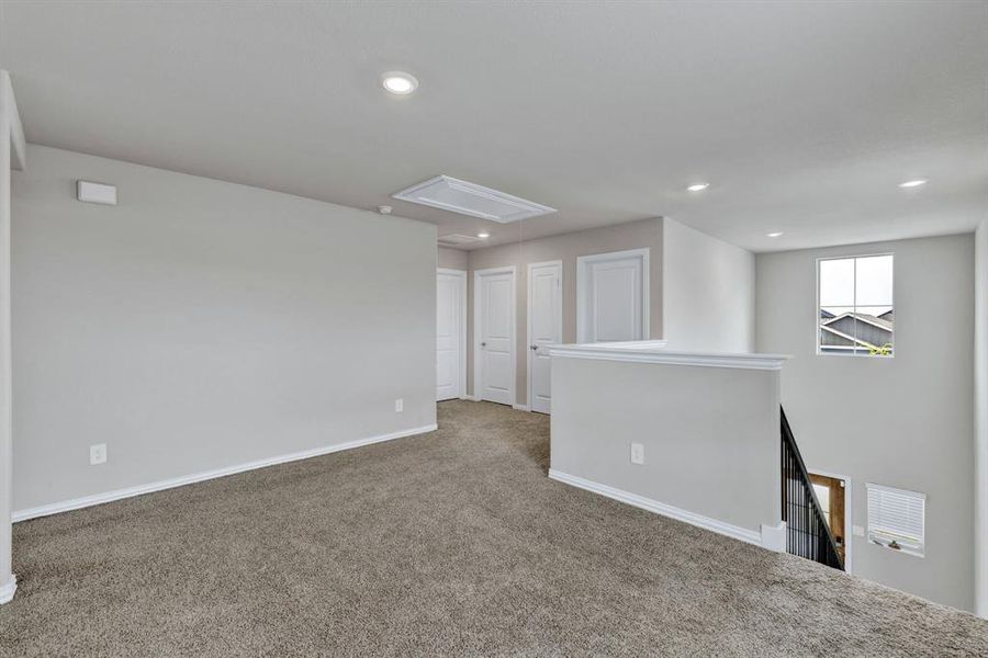 The property features a bright upper-level area with carpeting, recessed lighting, and a window providing natural light