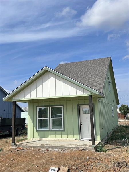 View of front of home with roof with shingles and board and batten siding