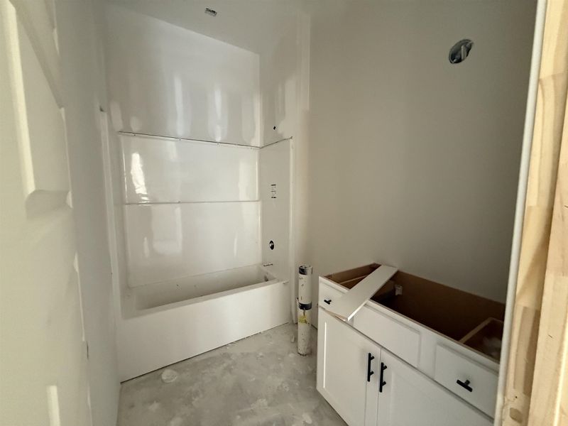 Bathroom featuring unfinished concrete flooring and tub / shower combination