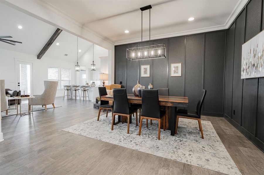 Dining room with notable chandelier, wood-type flooring, and vaulted ceiling with beams