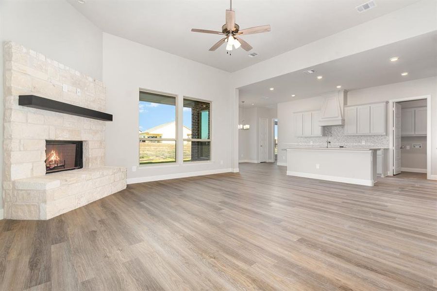 Unfurnished living room featuring a fireplace, recessed lighting, a ceiling fan, and light wood finished floors