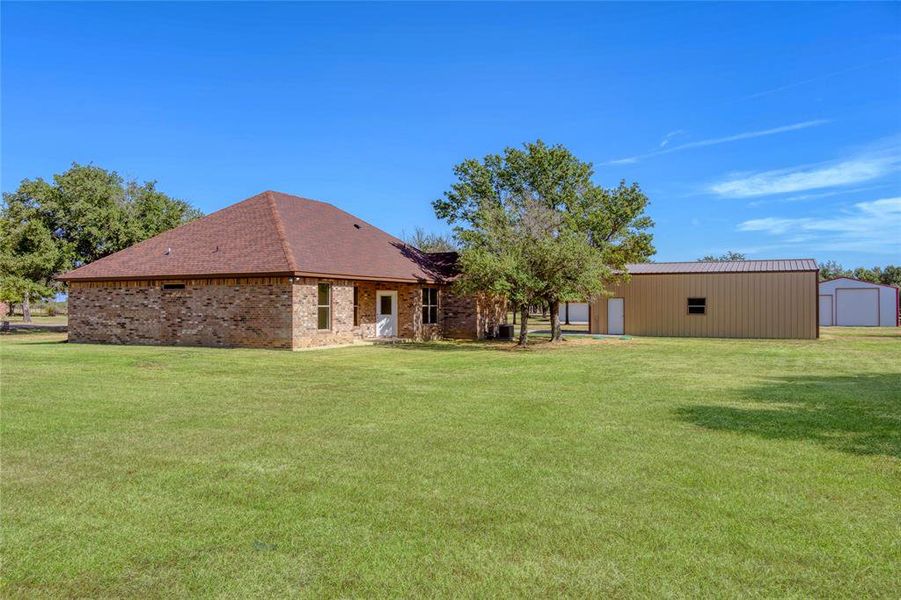 Back of property with a shed and a lawn