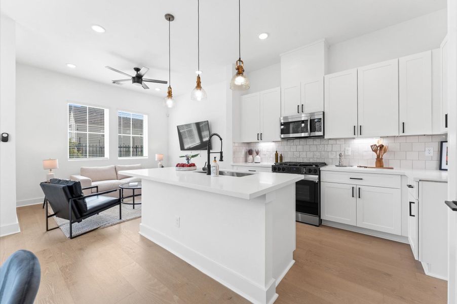 At the heart of this open-concept kitchen lies a stunning oversized island, offering generous prep space, sleek quartz countertops, and seating area. Whether you're hosting a dinner party or enjoying a casual breakfast, this island is the perfect gathering spot. Pendant lighting adds a touch of elegance, and the deep sink makes it as functional as it is beautiful.