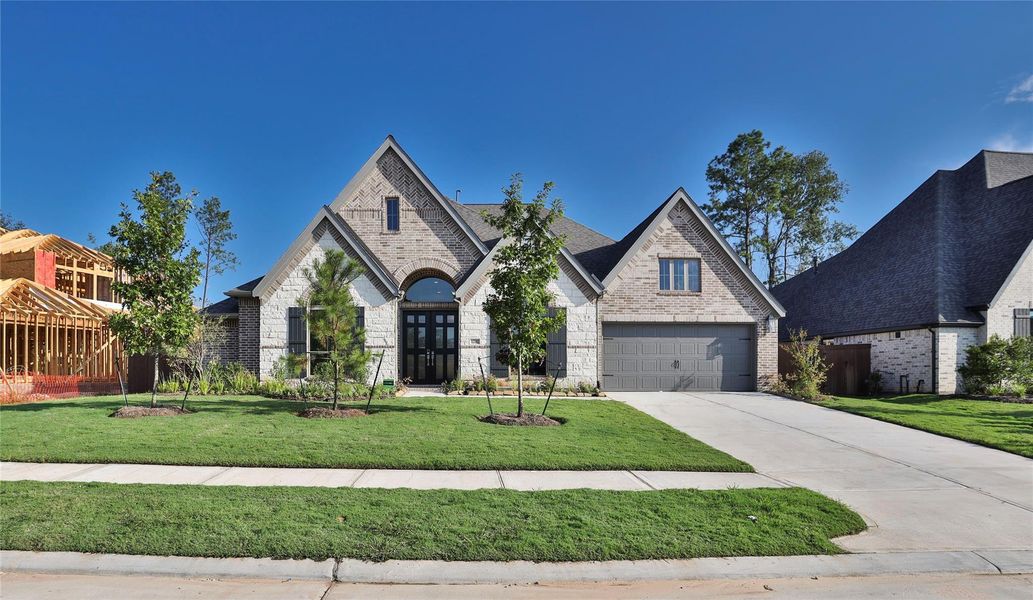 Front exterior of a new home in Evergreen 70', Conroe, TX, highlighting curb appeal (Image 1).