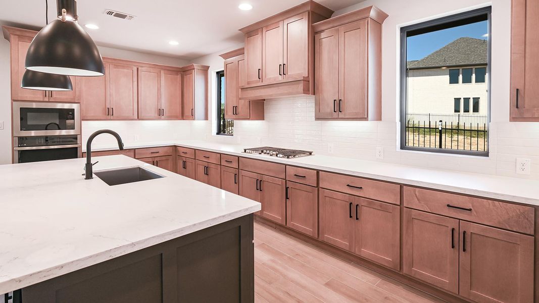 Kitchen featuring appliances with stainless steel finishes, decorative light fixtures, decorative backsplash, light stone counters, and recessed lighting Kitchen featuring appliances with stainless steel finishes, decorative light fixtures, decorative backsplash, light stone counters, and recessed lighting