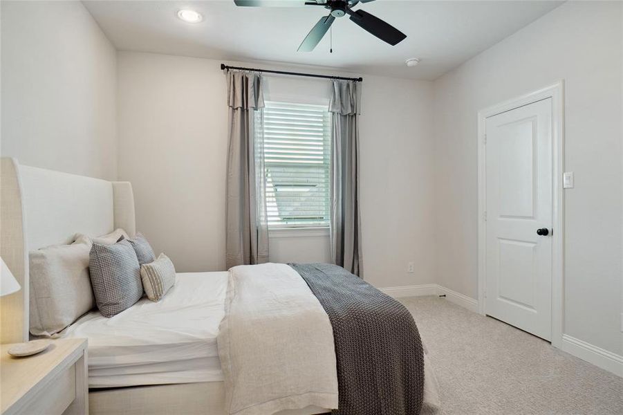 Carpeted bedroom with ceiling fan