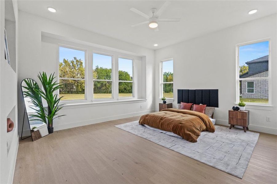 Bedroom featuring light wood-type flooring, recessed lighting, and a ceiling fan Bedroom featuring light wood-type flooring, recessed lighting, and a ceiling fan