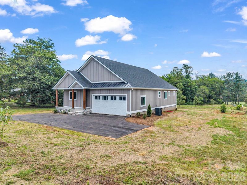 Front right view of custom modern farmhouse, 2 car attached garage, covered front porch and hardyboard siding Front right view of custom modern farmhouse, 2 car attached garage, covered front porch and hardyboard siding