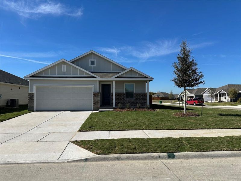 View of front of house featuring a front yard, a garage, and central air condition unit