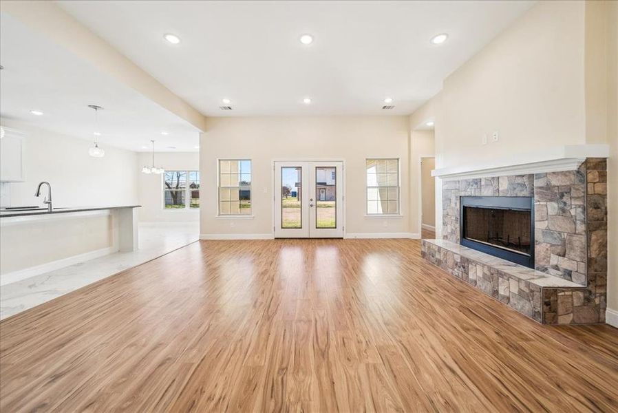 Unfurnished living room featuring a fireplace, light wood-type flooring, and sink