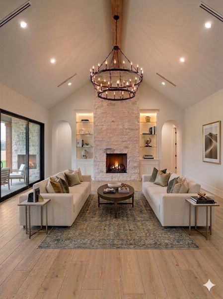 Vaulted living room featuring a floor-to-ceiling stone fireplace, illuminated built-ins, exposed beam accents, and expansive sliding glass doors for seamless indoor-outdoor living. Virtually Staged. Vaulted living room featuring a floor-to-ceiling stone fireplace, illuminated built-ins, exposed beam accents, and expansive sliding glass doors for seamless indoor-outdoor living. Virtually Staged.