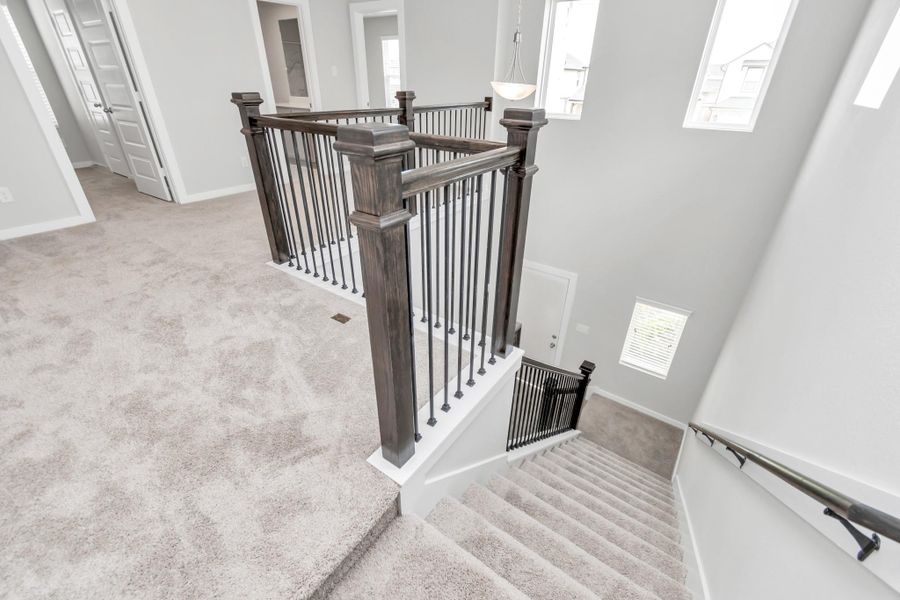 Come upstairs and relish a day of relaxation in this loft area! Ideal as an additional living space or game room, it boasts plush carpeting, high ceilings, custom paint, and windows that flood the area with abundant natural light. Sample photo of completed home with similar floor plan. Actual colors and selections may vary.