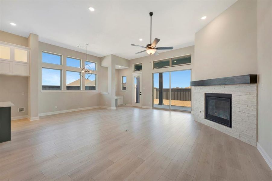 Unfurnished living room featuring a fireplace, recessed lighting, a ceiling fan, and light wood-type flooring Unfurnished living room featuring a fireplace, recessed lighting, a ceiling fan, and light wood-type flooring