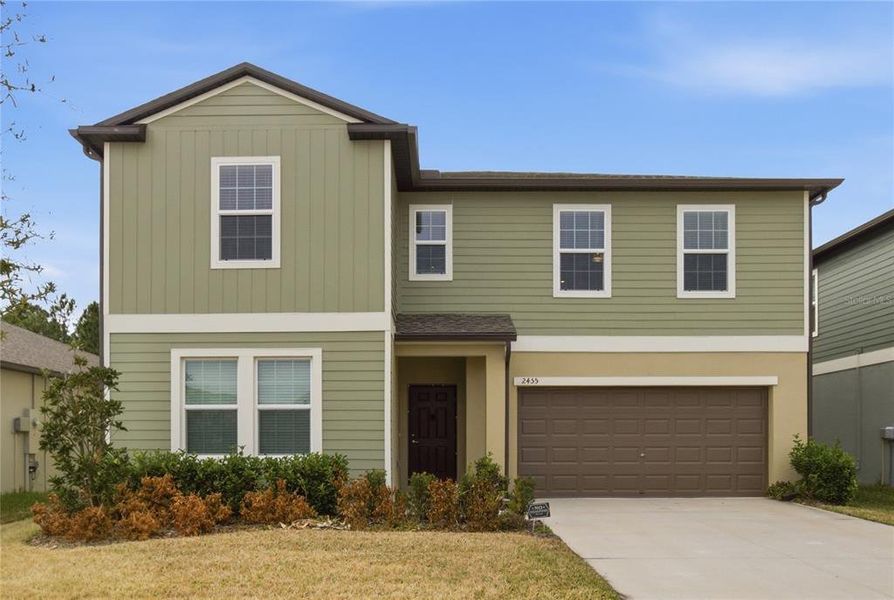 Front exterior of a new home in Two Rivers, Zephyrhills, FL, highlighting curb appeal (Image 18). Front exterior of a new home in Two Rivers, Zephyrhills, FL, highlighting curb appeal (Image 18).
