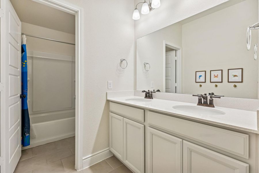 Third bathroom upstairs with dual vanity and separate door to shower