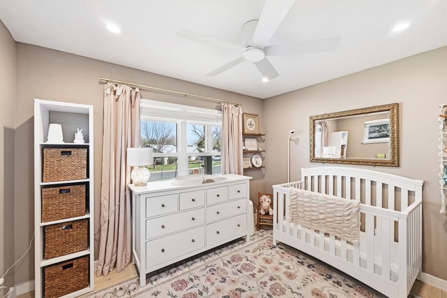 Bedroom with a crib, ceiling fan, recessed lighting, and light wood finished floors