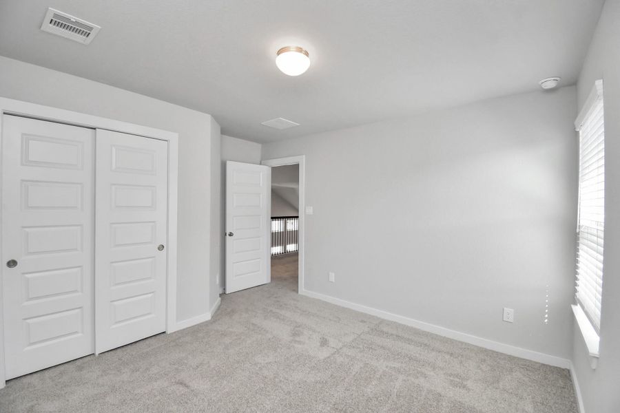 Generously sized secondary bedrooms featuring spacious closets, soft and inviting carpeting underfoot, large windows allowing plenty of natural light, and the added touch of privacy blinds for your personal retreat. Sample photo of completed home with similar floor plan. Actual colors and selections may vary. Generously sized secondary bedrooms featuring spacious closets, soft and inviting carpeting underfoot, large windows allowing plenty of natural light, and the added touch of privacy blinds for your personal retreat. Sample photo of completed home with similar floor plan. Actual colors and selections may vary.