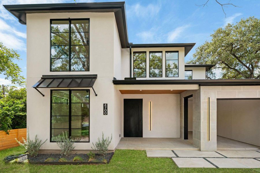 Clean modern architectural lines define this two-story exterior with stucco and stone finishes.