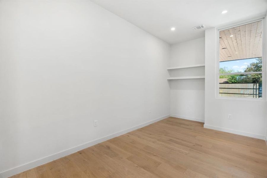 Empty room with light wood-type flooring and recessed lighting