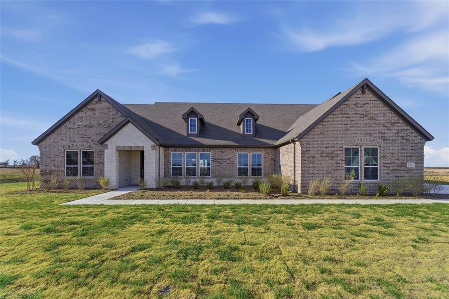 View of front of property featuring brick siding and a front yard